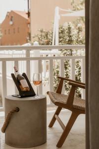 a glass of wine and a chair on a balcony at TRINITY THE HOTEL in Ammouliani