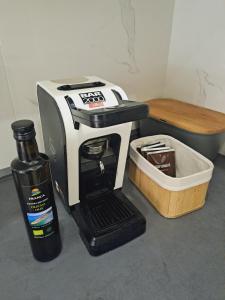 eine schwarze und weiße Kaffeemaschine neben einem Behälter in der Unterkunft Estate Franca Wine and Olive oil in Koper