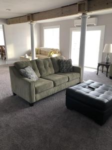 a living room with a couch and a ottoman at Mariners Cove cottage in Norfolk