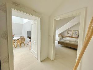 a white room with a bed and a mirror at Apartmá Linda 1880 in Karlovy Vary