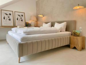 a bedroom with a large bed with white sheets and pillows at Apartmá Linda 1880 in Karlovy Vary