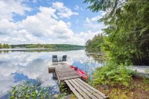 - un quai avec 2 chaises et un bateau sur un lac dans l'établissement Gloversville Retreat with Patio and Lake Access!, à Gloversville