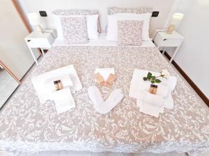 eine Aussicht über ein Bett mit weißer Bettwäsche und Handtüchern in der Unterkunft Puccio Home Stadio - City Center in Verona