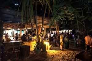 a crowd of people standing around a bar at night at Demani Lodge Zanzibar in Paje