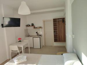 a bedroom with a bed and a table and a kitchen at Kostas Apartments in Stalís +12 photos
