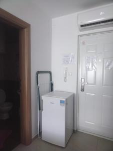 a white refrigerator in a room next to a door at Studio apartman MIR in Kanjiža