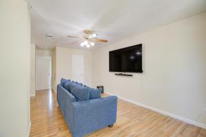 a living room with a blue couch and a flat screen tv at Houston Vacation Rental 14 Mi to Downtown in Houston