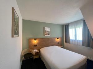 a hotel room with a bed and a window at Hotel Le Progres in Angers