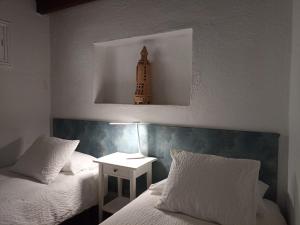 a bedroom with two beds and a night stand with a lamp at Dos Violetas in Mocanal