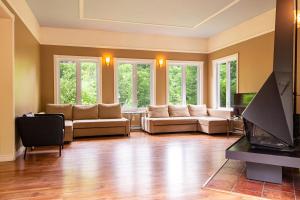 a living room with couches and a flat screen tv at Les Chalets Tourisma - Chalet au bord de l'eau avec spa et foyer - Le Draveur in Saint-Raymond