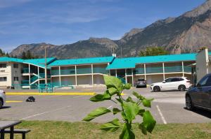 a parking lot with cars parked in front of a building at Canadas Best Value Inn Mile-0-Motel Lillooet in Lillooet