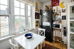 a kitchen with a white table and a refrigerator at Stylish Central London Flat Near Tower Bridge in London