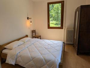 sypialnia z białym łóżkiem i oknem w obiekcie Gîte Loubet w mieście Saint-Jacques-en-Valgodemard