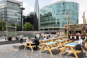 persone sedute ai tavoli in una città con edifici di Stylish Central London Flat Near Tower Bridge a Londra