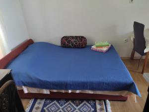 łóżko z niebieską kołdrą i 2 torbami w obiekcie Apartments Berbić w Szybeniku