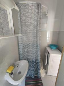 baño con lavabo y cortina de ducha en Apartments Berbić, en Šibenik