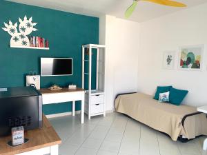 - une chambre avec un lit, un bureau et une télévision dans l'établissement 73059, à Ugento