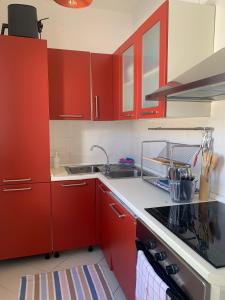 - une cuisine avec des placards rouges et un évier dans l'établissement 73059, à Ugento