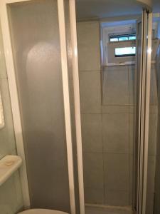 a shower with a glass door in a bathroom at City Center apartment in Podgorica