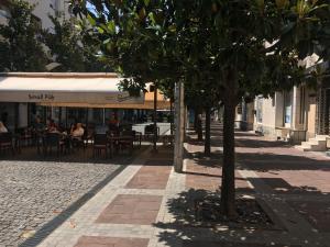 a street with tables and chairs and a tree at City Center apartment in Podgorica