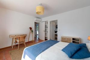 a bedroom with a large bed and a desk at Penina Golf - Villa de luxe em Alvor no Algarve in Portimão