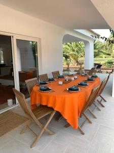 a dining room with a table with orange table cloth at Penina Golf - Villa de luxe em Alvor no Algarve in Portimão