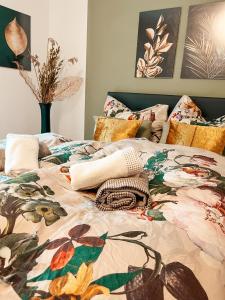 a bed with a floral comforter and pillows on it at Panorama-Refugium in Bad Koetzting