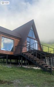 Casa con techo negro y ventana grande en Vista cottage en Kazbegi