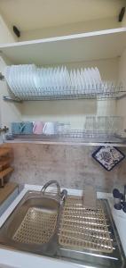 eine Küche mit Spüle und Tellern auf einem Regal in der Unterkunft Casa Mare Blu Agropoli - Blu Zaffiro in Agropoli