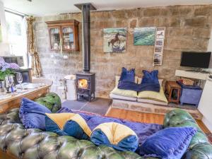 uma sala de estar com um sofá e uma lareira em Daffodil Cottage em Danby