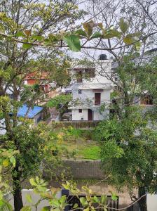 een uitzicht op een huis van achter enkele bomen bij Micro homestay mulavukad in Ernakulam