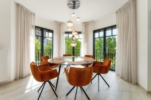 een eetkamer met een glazen tafel en stoelen bij Zonnig Luxueuze Appartementen La Coronne in Knokke-Heist