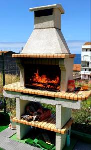 um forno de pizza com um fogo dentro dele em RINCON DO MAR 1 IZ em A Guarda