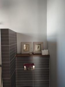 Un baño con una estantería con dos fotos. en Climbers' Nest en Kalymnos