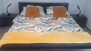 uma cama com um cobertor e duas almofadas em Apartament Sosnowa em Krasnobród