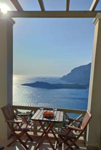 una mesa y sillas en un balcón con vistas al agua en Climbers' Nest en Kalymnos