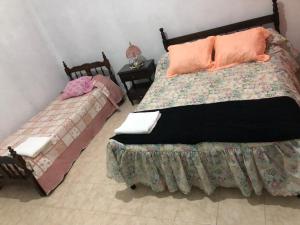 een slaapkamer met 2 bedden en kussens erop bij Casa “El Rodeo” in El Rodeo
