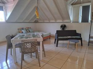 ein Wohnzimmer mit einem Tisch und einem Bett in der Unterkunft STUDIO 1 - Grande Anse - 4 pers - proche bourg in Terre-de-Haut