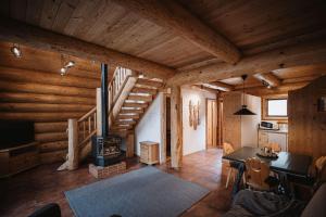 a living room with a staircase in a log cabin at Nancy's Holiday Homes Dolomites in Rasùn di Sotto