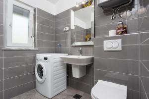 łazienka z pralką i umywalką w obiekcie Villa LM w mieście Krnica