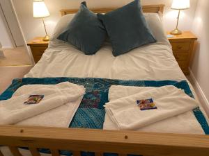 uma cama com duas toalhas e duas almofadas em Close to sea and South Downs national park - Sompting em Sompting
