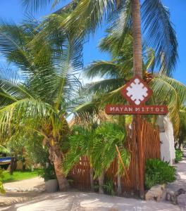 una señal de cocina maya colgada de una palmera en Mayan Mittoz en Holbox Island