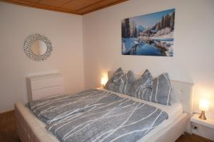 Alpenvilla Tirol Zentral في فولس: غرفة نوم بسرير مع صورة على الحائط
