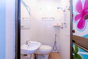 Baño blanco con aseo y lavamanos en Spring Inn Hotel, en Sungai Petani