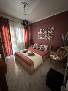 - une chambre avec un grand lit aux murs rouges dans l'établissement G & A APARTMENT, à Orestiáda