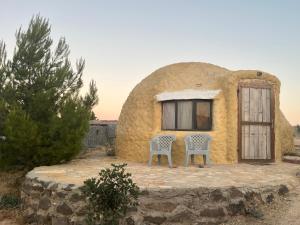 a couple of chairs sitting outside of a house at Al-Nawatef ECO camp- Dana Nature Reserve in Dana