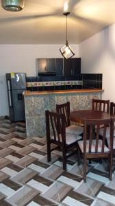 cocina con mesa, sillas y nevera en Apartamento bustos en Puerto Triunfo