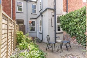 two chairs and a table in front of a house at Charming 3-Bedroom Home in Historic Lincoln Ideal for Families in Lincolnshire