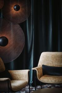 a living room with two chairs and a lamp at nancy's Holiday Homes Dolomites in Rasùn di Sotto