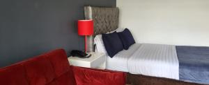 a bedroom with a bed and two red chairs at Hotel Urban Parque 93 in Bogotá